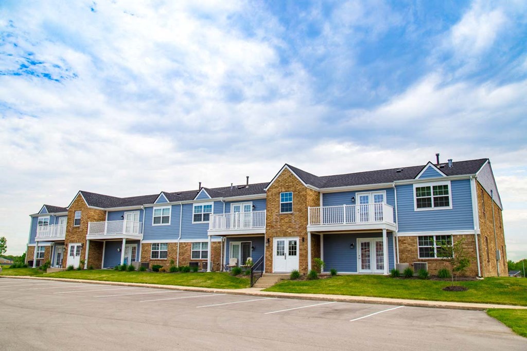 a row of blue and brick houses with a parking lot