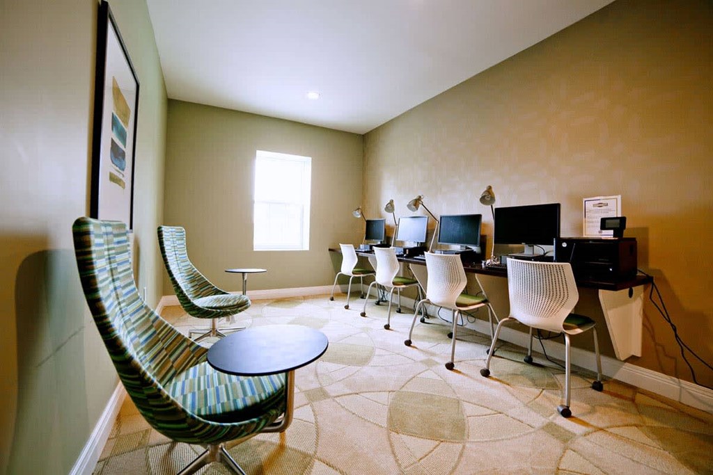 a conference room with computers and chairs and a table