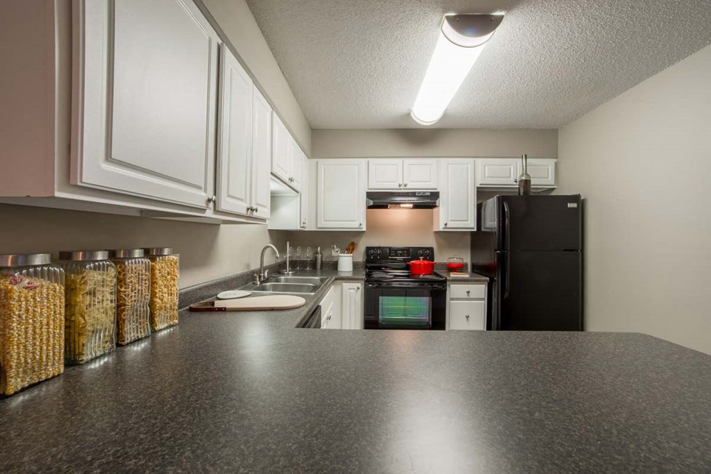 a kitchen with a counter top and a black refrigerator