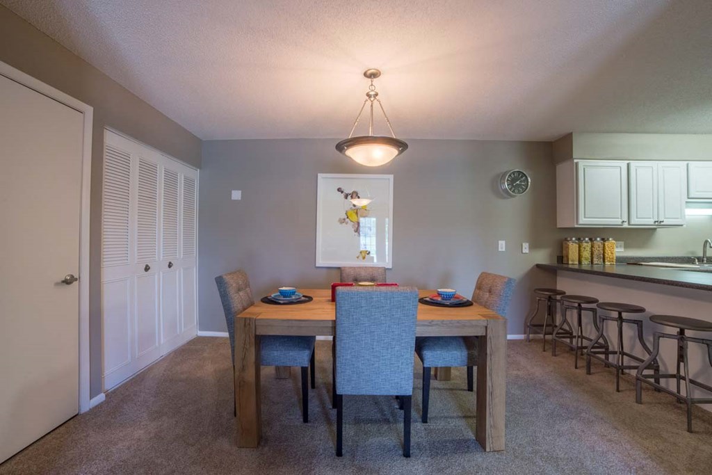 a dining room with a wooden table and chairs