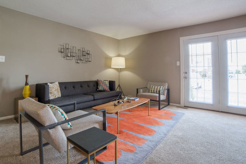 a living room with a couch and chairs and a coffee table