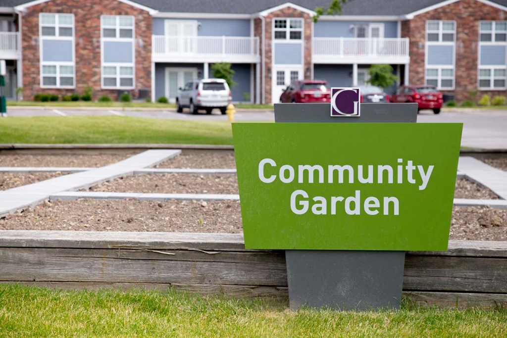 a sign for the community garden in front of a building
