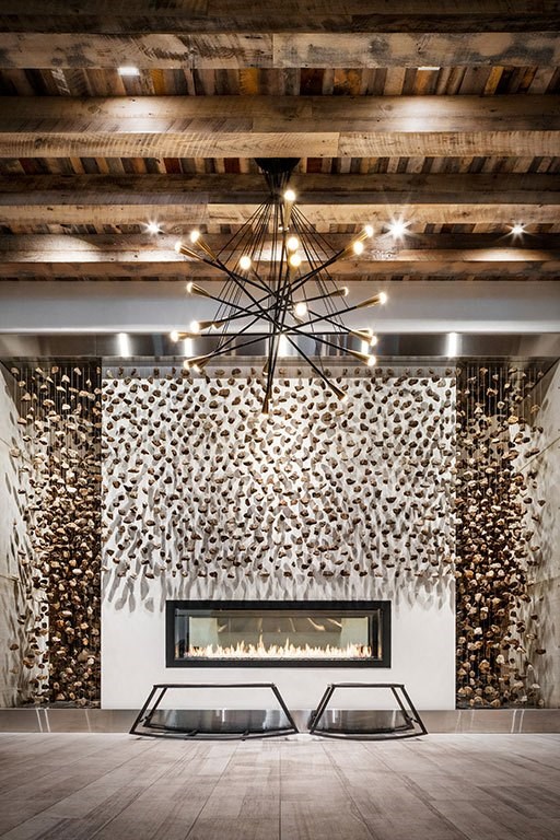 a living room with a fireplace and a wooden ceiling with a chandelier