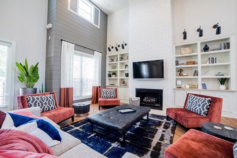 a living room with a white brick fireplace and a tv