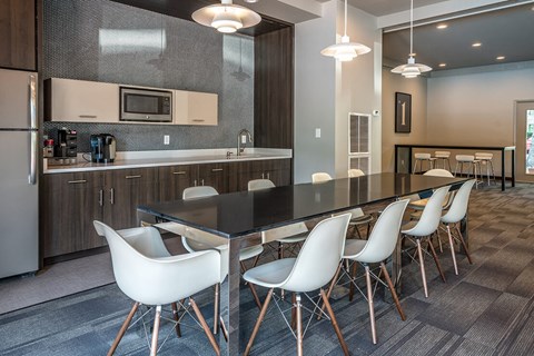 a kitchen with a long table and chairs