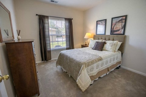 a bedroom with a bed and a dresser and a window