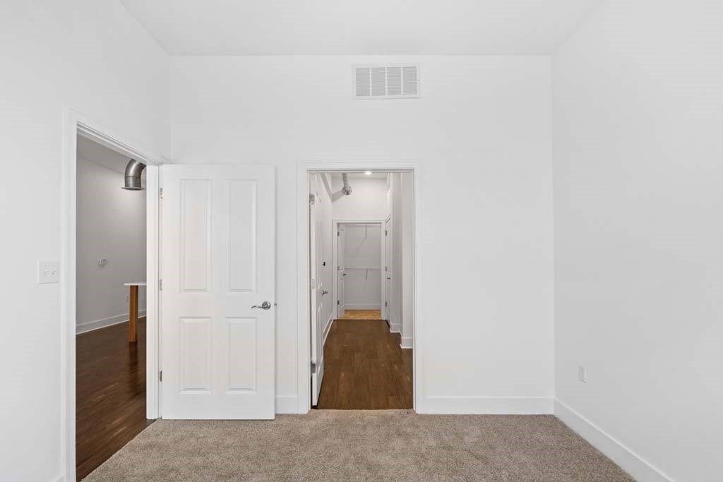A white room with a carpeted floor and a doorway leading to another room.at The Foundry, South Bend Indiana