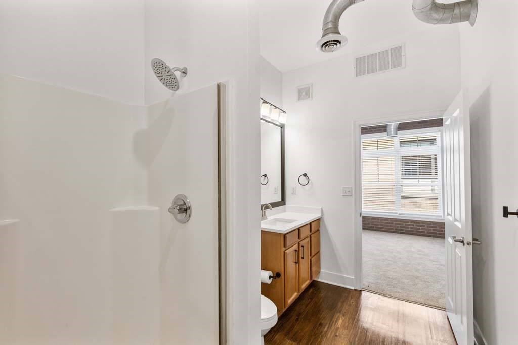 A bathroom with a walk in shower and a toilet.at The Foundry, South Bend Indiana