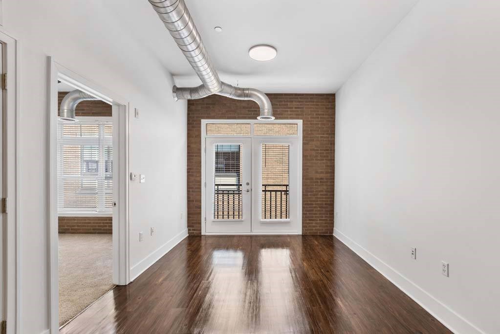 A room with a wooden floor and a white wall with a doorway leading to another room.at The Foundry, South Bend, IN 46617