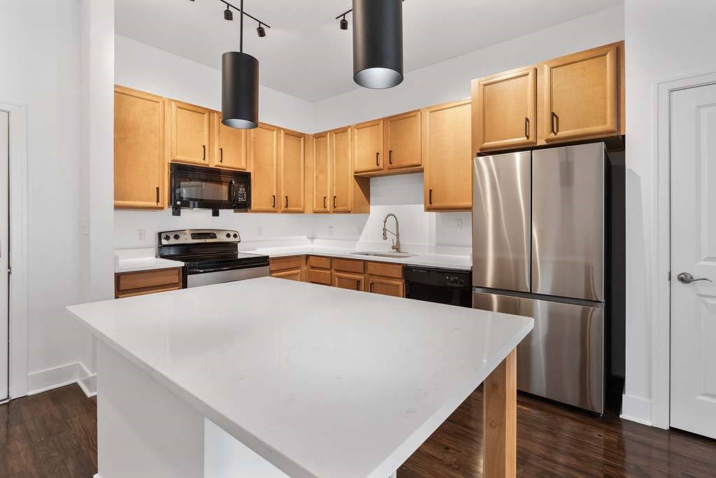 A kitchen with wooden cabinets and a white island.at The Foundry, South Bend, IN 46617