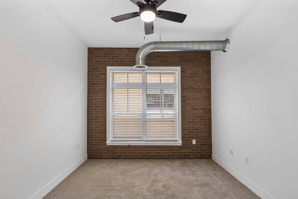 A room with a ceiling fan and a window with blinds.at The Foundry, South Bend Indiana