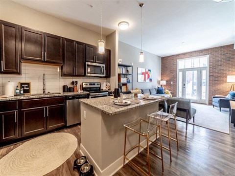 A kitchen with dark brown cabinets and a white island.