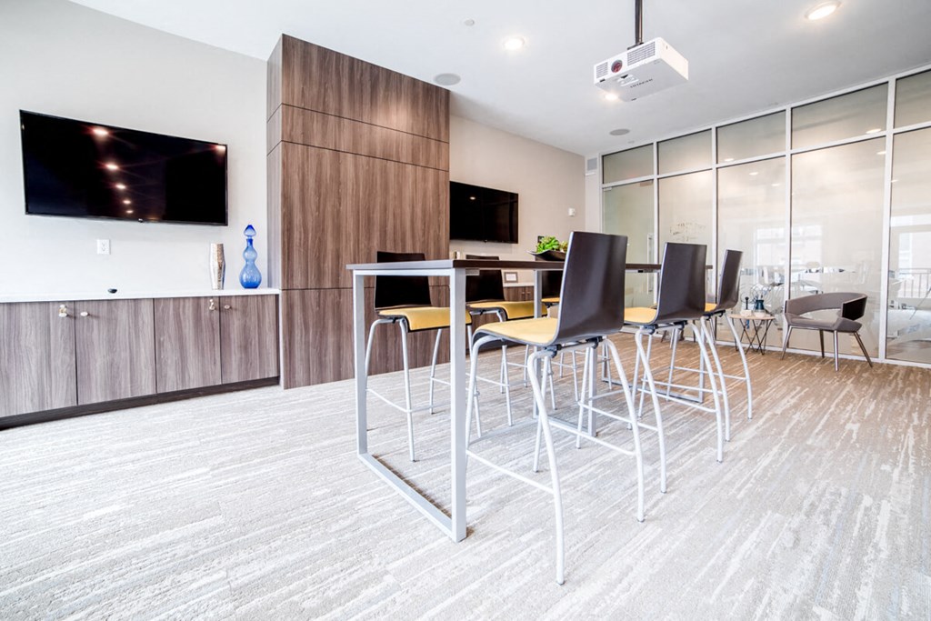 a bar with chairs and a table in a room with a tv at The Foundry, South Bend, IN