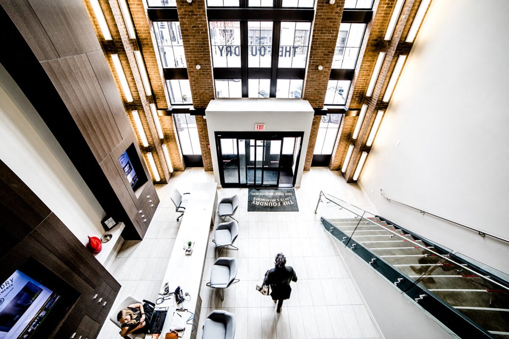 a woman walking through the lobby of a building at The Foundry, South Bend, 46617