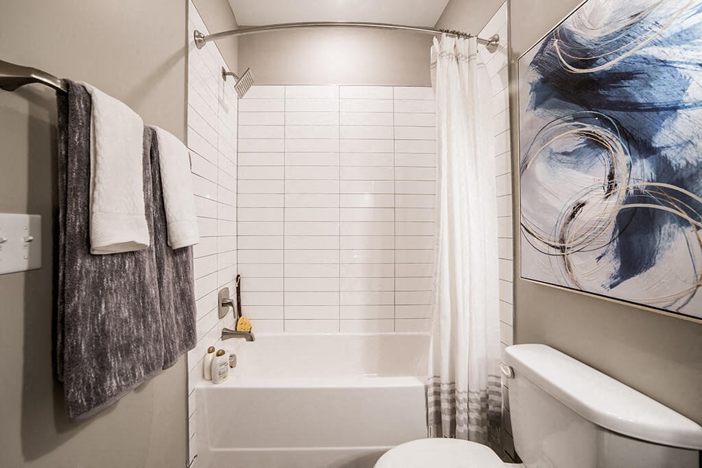 a bathroom with a white tub and a toilet at The Foundry, South Bend