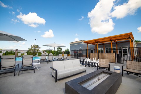 a patio with couches chairs and tables and a poolat The Century at Purdue Research Park-Student, West Lafayette, IN