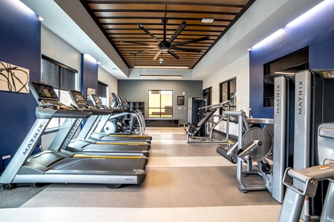 a gym with cardio equipment and a ceiling fan at The Century at Purdue Research Park-Student, West Lafayette, IN