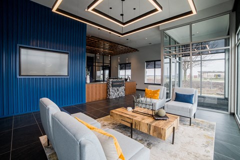 a living room with blue walls and white furniture at The Century at Purdue Research Park-Student, West Lafayette, IN 47906