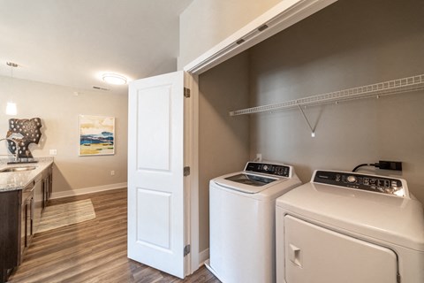 a washer and dryer in a laundry room with a sink and a door at The Century at Purdue Research Park-Student, Indiana