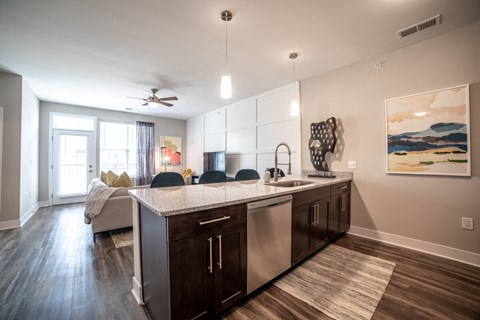 a kitchen with an island and a living room with a couch at The Century at Purdue Research Park-Student, West Lafayette, IN