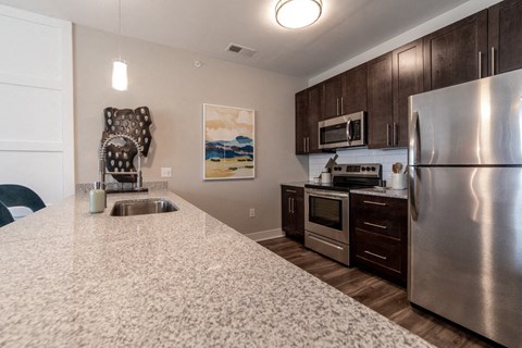 a kitchen with stainless steel appliances and granite counter tops at The Century at Purdue Research Park-Student, West Lafayette, IN 47906