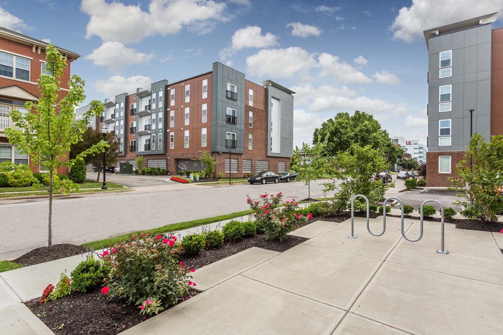 an exterior view of an apartment complex with a sidewalk and playground an exterior view of an apartment complex with a sidewalk and playground at 310 at Nulu Apartments-Student, Louisville, KY