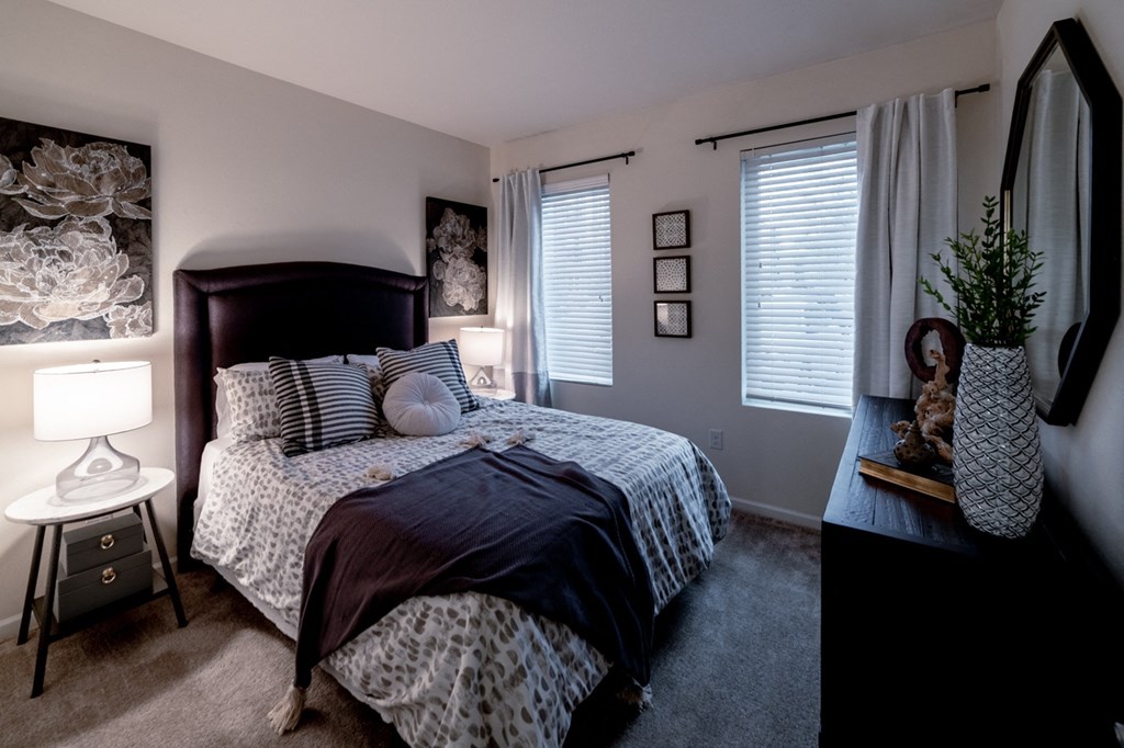 bedroom with a large bed and a dresser with a potted plant bedroom with a large bed and a dresser with a potted plant at 310 at Nulu Apartments-Student, Louisville, KY 40202