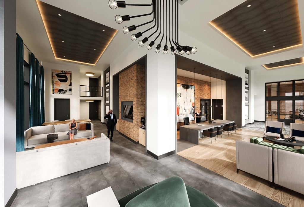 Modern leasing office at Contrast OTR in Cincinnati, Ohio, showcasing high ceilings, contemporary design elements, industrial-inspired lighting, and comfortable seating areas for residents and guests