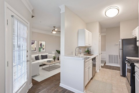 A modern kitchen with white cabinets and appliances.