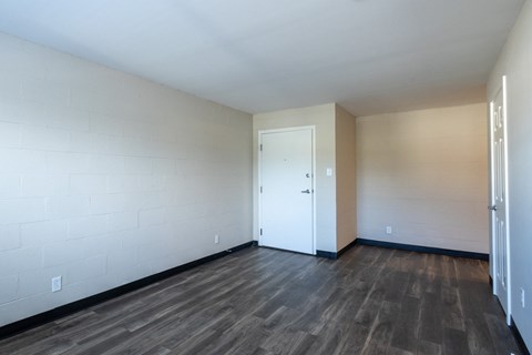 an empty living room with wood flooring and a white door