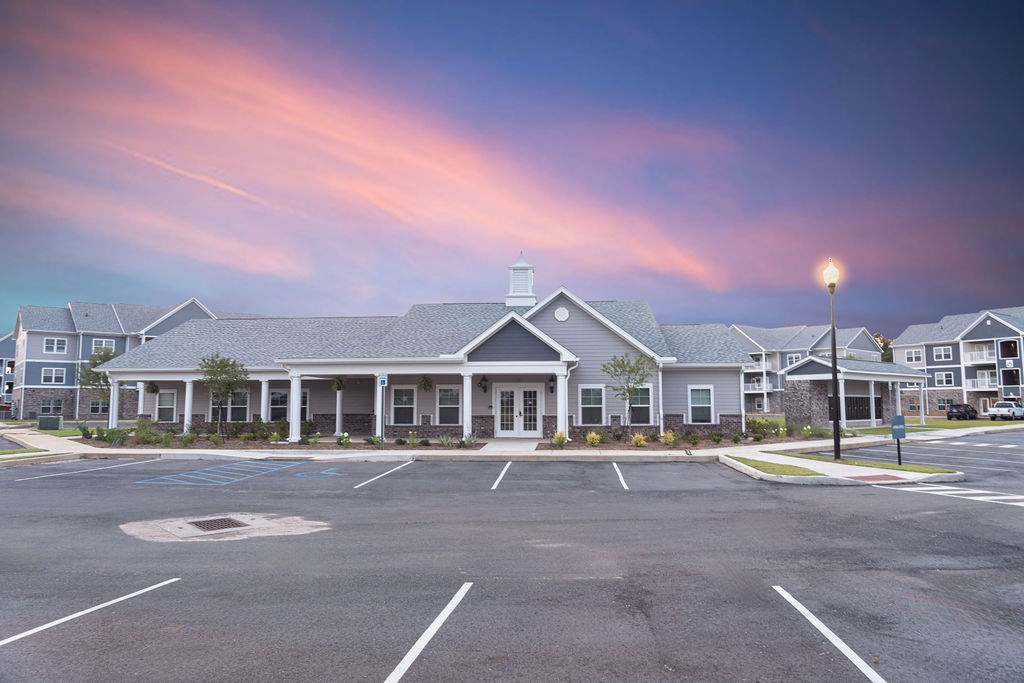 A parking lot in front of a building with a blue sky above.