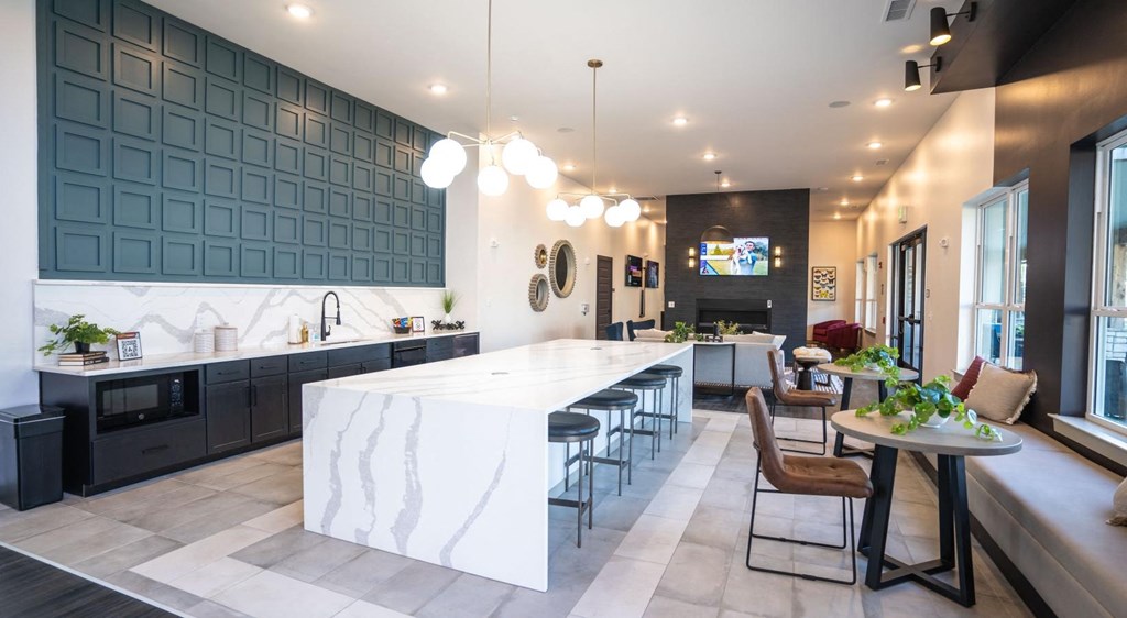 a kitchen with a large island and a table with chairs
