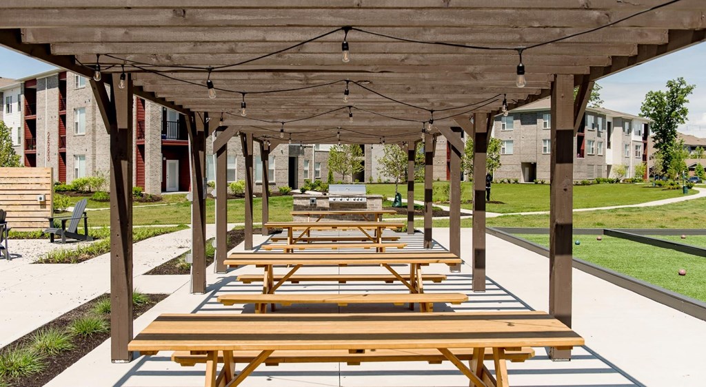 a row of picnic tables under a covered pavilion at Echo Park at Perry Crossing Apartments, Indiana