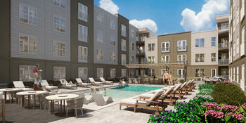 A pool area with lounge chairs and a person standing in the pool at Portrait Midtown Apartments, Carmel, Indiana