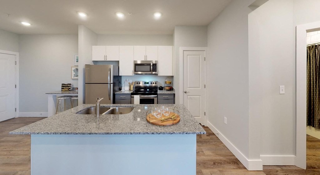 a kitchen with a granite counter top and a stainless steel refrigerator at Echo Park at Perry Crossing Apartments, Indiana, 46168