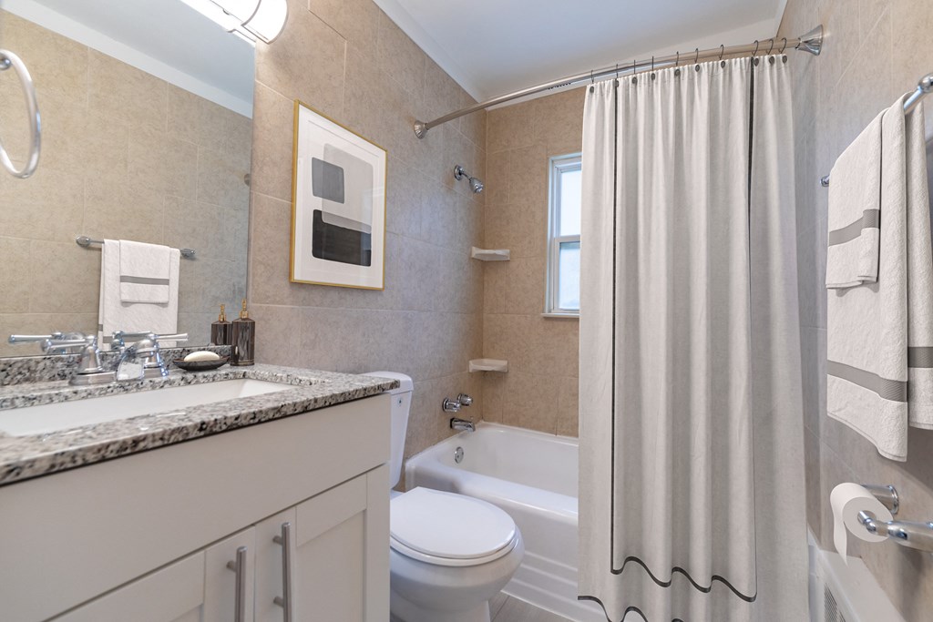 a bathroom with a white toilet next to a white bathtub