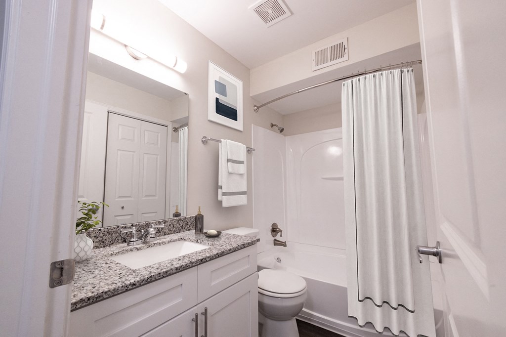 a bathroom with white cabinets and a white shower curtain