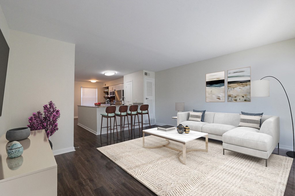 a living room with a couch coffee table and a kitchen in the background