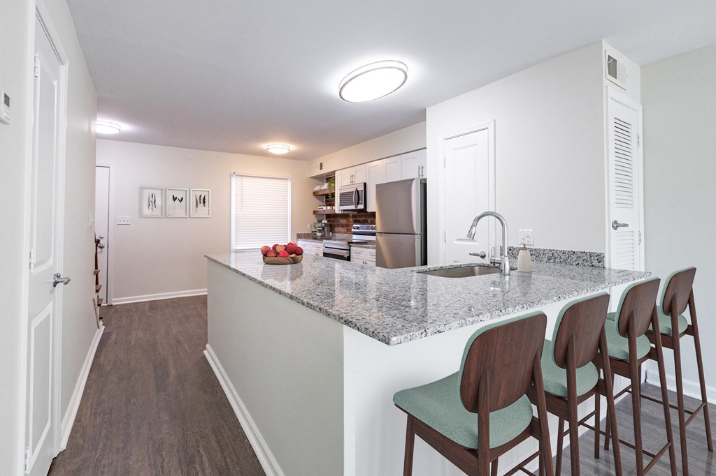 a kitchen with a granite counter top and three stools