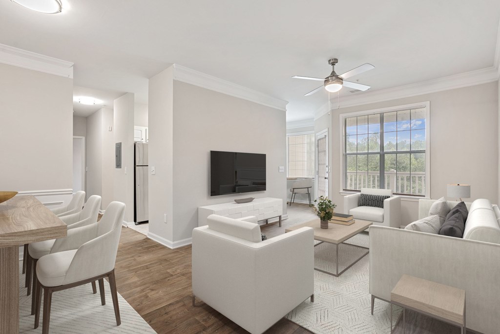 A living room with a television, couch, and chairs.