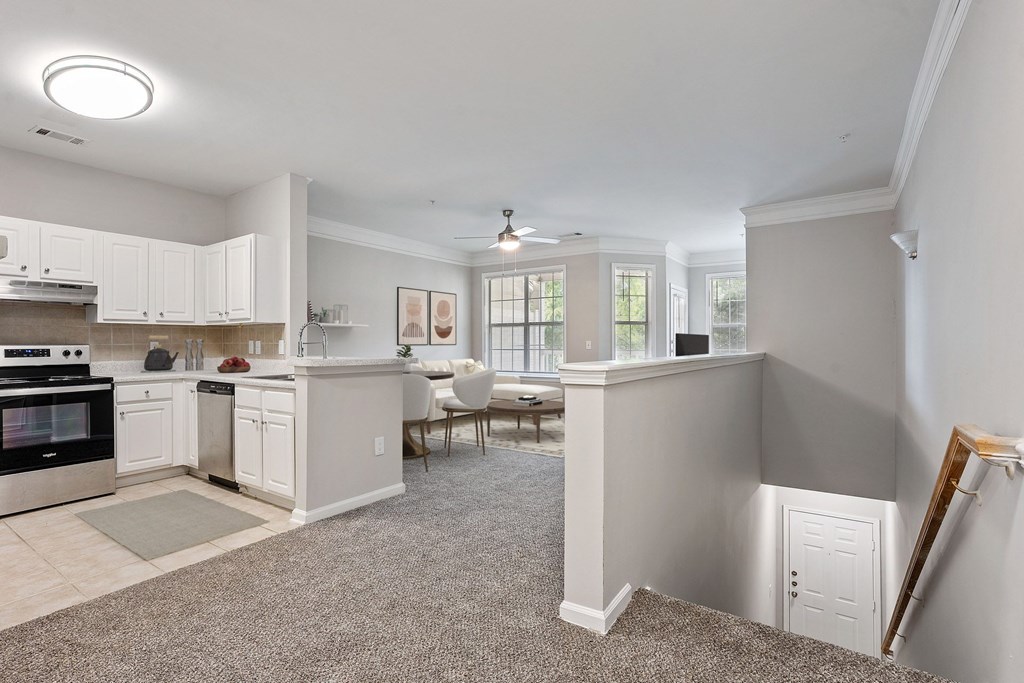 A kitchen with white cabinets and a dining table.