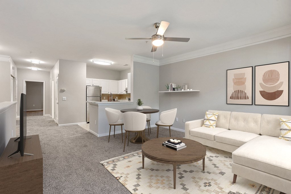 A living room with a white couch, a coffee table, and a television.