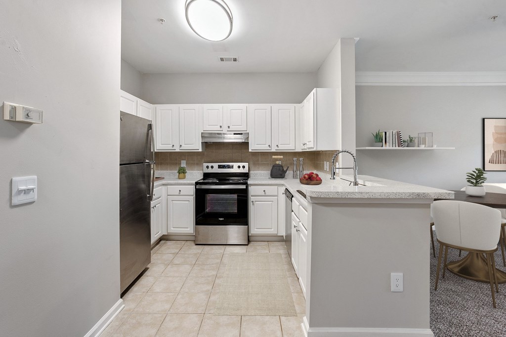A kitchen with white cabinets and a black stove top oven.
