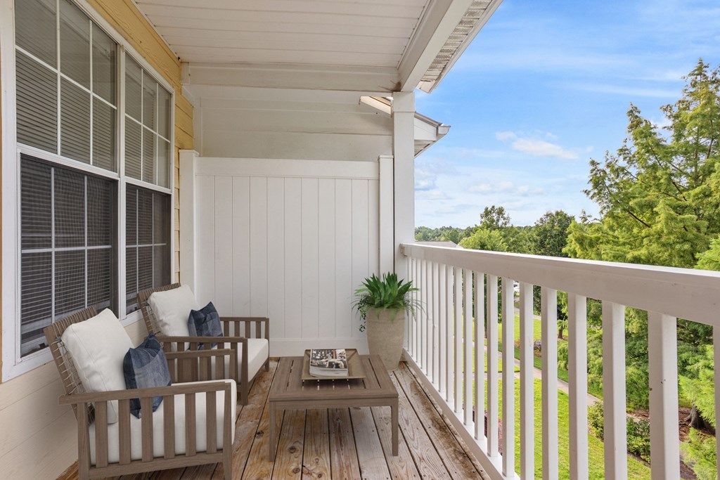 A wooden porch with a bench and a table.