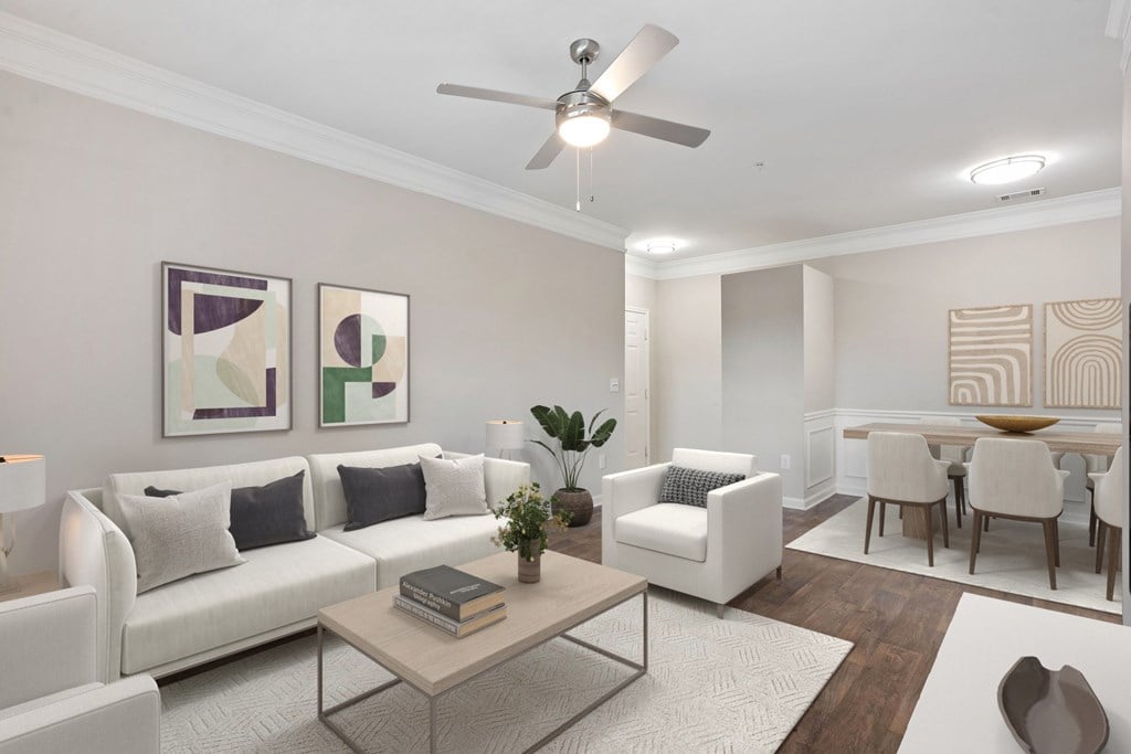 A living room with a white couch, a coffee table, and a dining table.