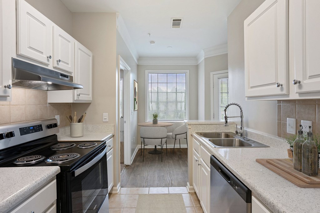 A kitchen with a black stove top oven and white cabinets.