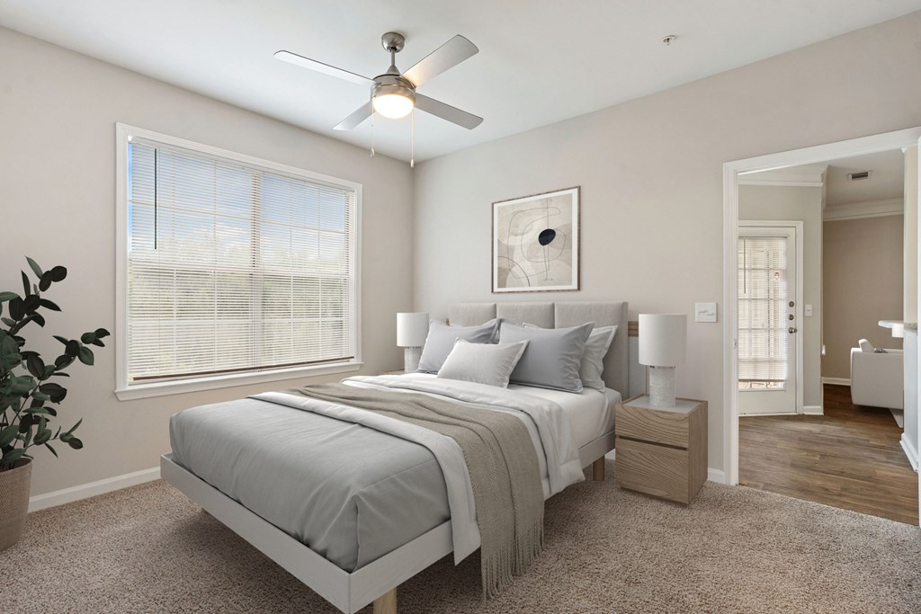 A bedroom with a bed, nightstand, and a ceiling fan.