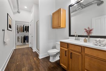 A bathroom with a toilet, sink, and a mirror.