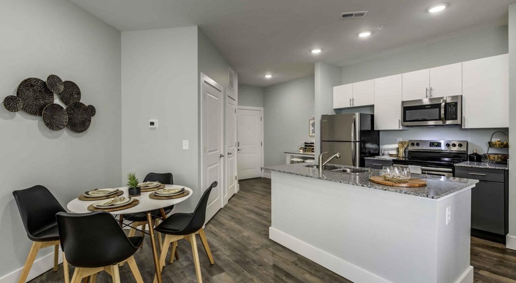a kitchen with a table and chairs next to a counter top at Echo Park at Perry Crossing Apartments, Plainfield
