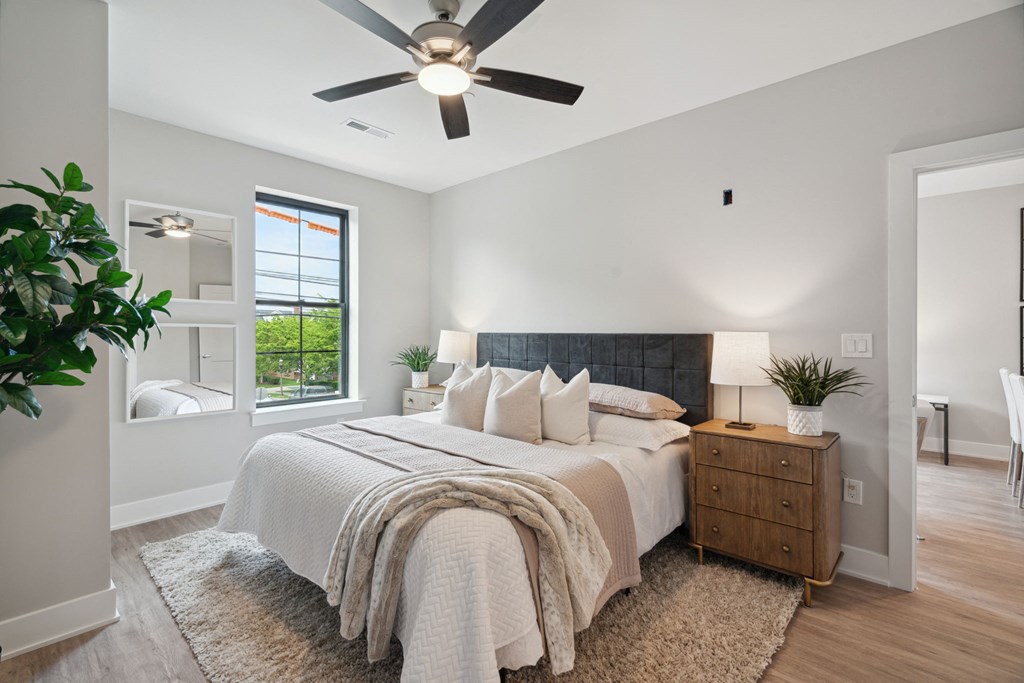 an open bedroom with a bed and a ceiling fan